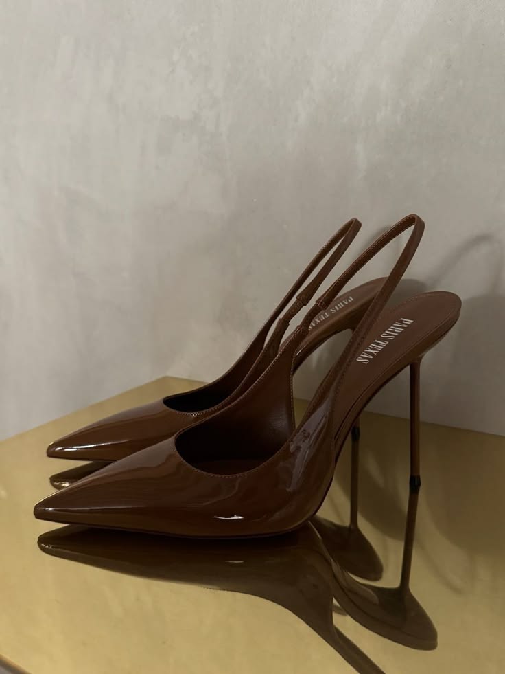 Paris Texas brown patent leather slingback stiletto pumps with pointed toe and slim metal heel on a gold surface